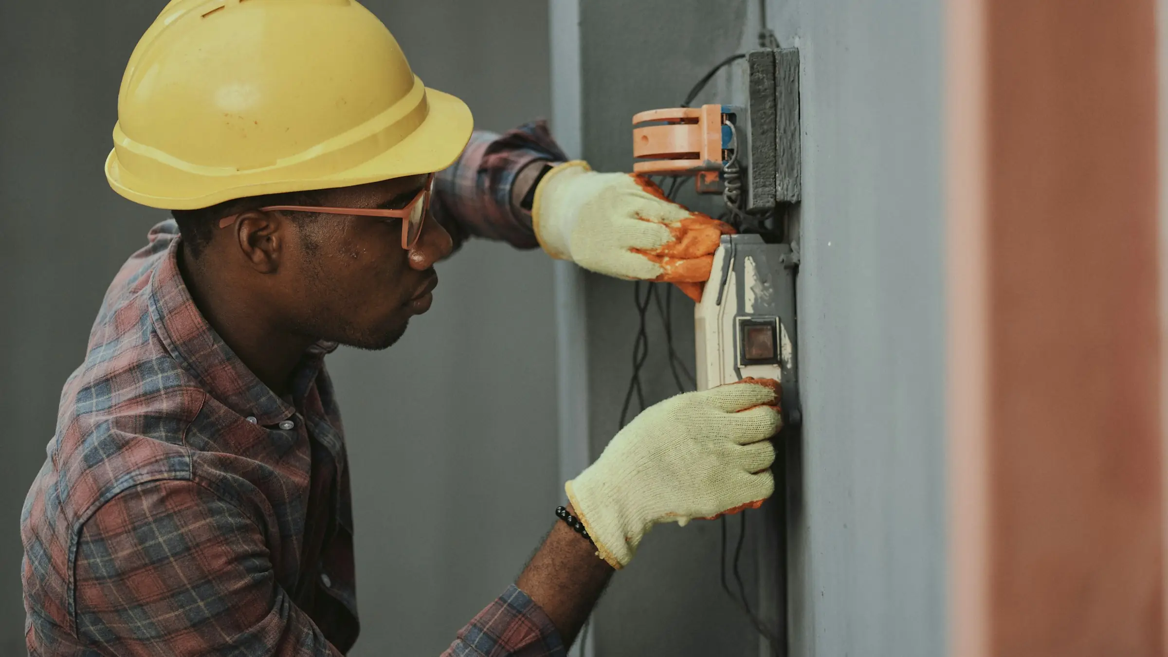 An electrician wiring a device box on site